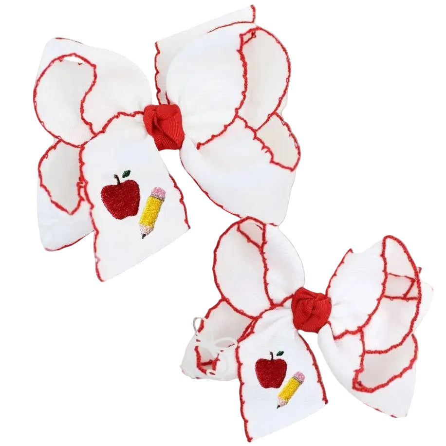 White hair bow with red accents featuring an apple and pencil design on a white background