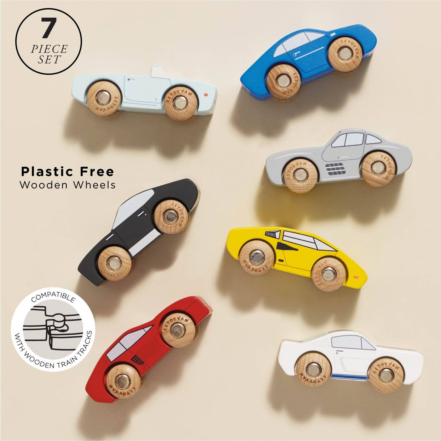 Seven Classic Wooden Sports Cars by Le Toy Van, Inc. are shown on a beige background in two columns. The 7-piece plastic-free set features round wooden wheels and is compatible with train tracks, as highlighted in a circular label.