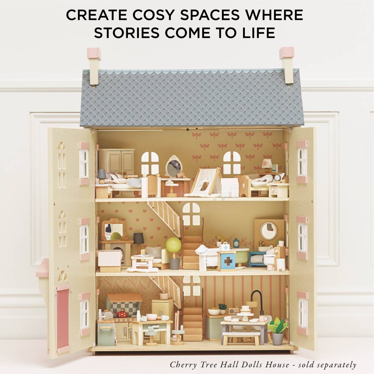 A fully furnished three-floor dollhouse by Le Toy Van, Inc., with charming miniature furniture in every room. Text above: Create cosy spaces where stories come to life. Note: Complete Dolls House Furniture sold separately.