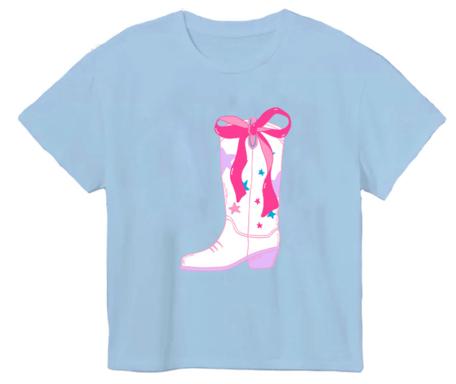 The Azarhia Rodeo Sequin Bow Boot Boxy Tee features a comfy boxy fit, a graphic of a white cowboy boot with pink and blue stars, and a large sequin bow detail for effortless charm.