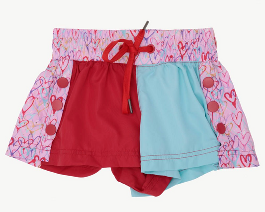 The Azarhia Heart Collage Color Block Shorts feature a pink waistband and sides with a heart print, a red front left panel, light blue right panel, and red drawstring—perfect playful style for Valentine's Day!.
