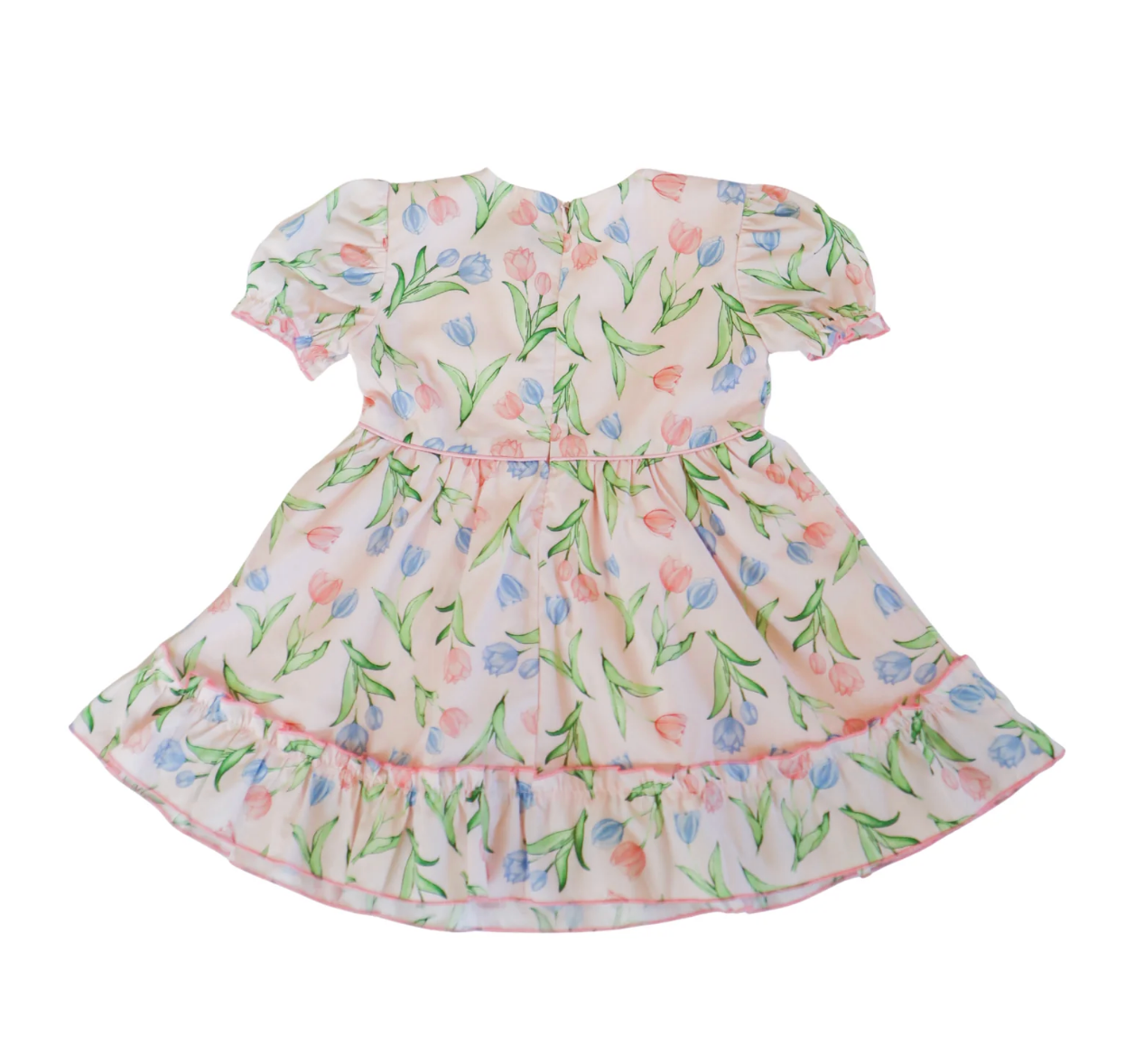 The Hollis Baker Everly Tulips Dress is a short-sleeved, knee-length pink dress with blue and pink tulip prints, puffed sleeves, and a ruffled hem—ideal for spring occasions. Shown laid flat on a white background.
