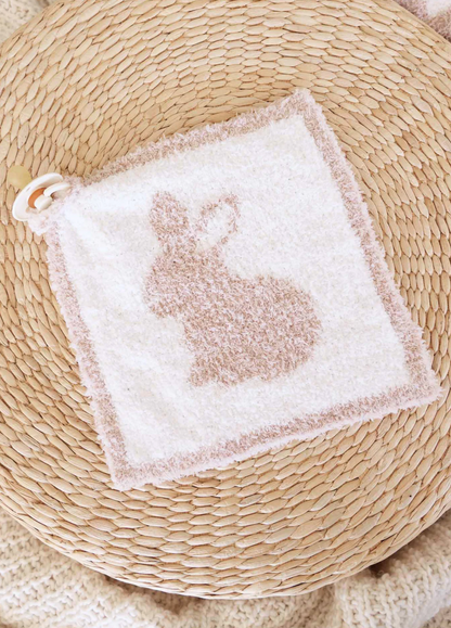 The Caden Lane CuddleLane™ Luxe Lovey | Bunny Foo Foo is a soft, square baby cloth with a beige bunny silhouette, textured border, and pacifier attachment for comfort—shown resting on a woven straw surface.