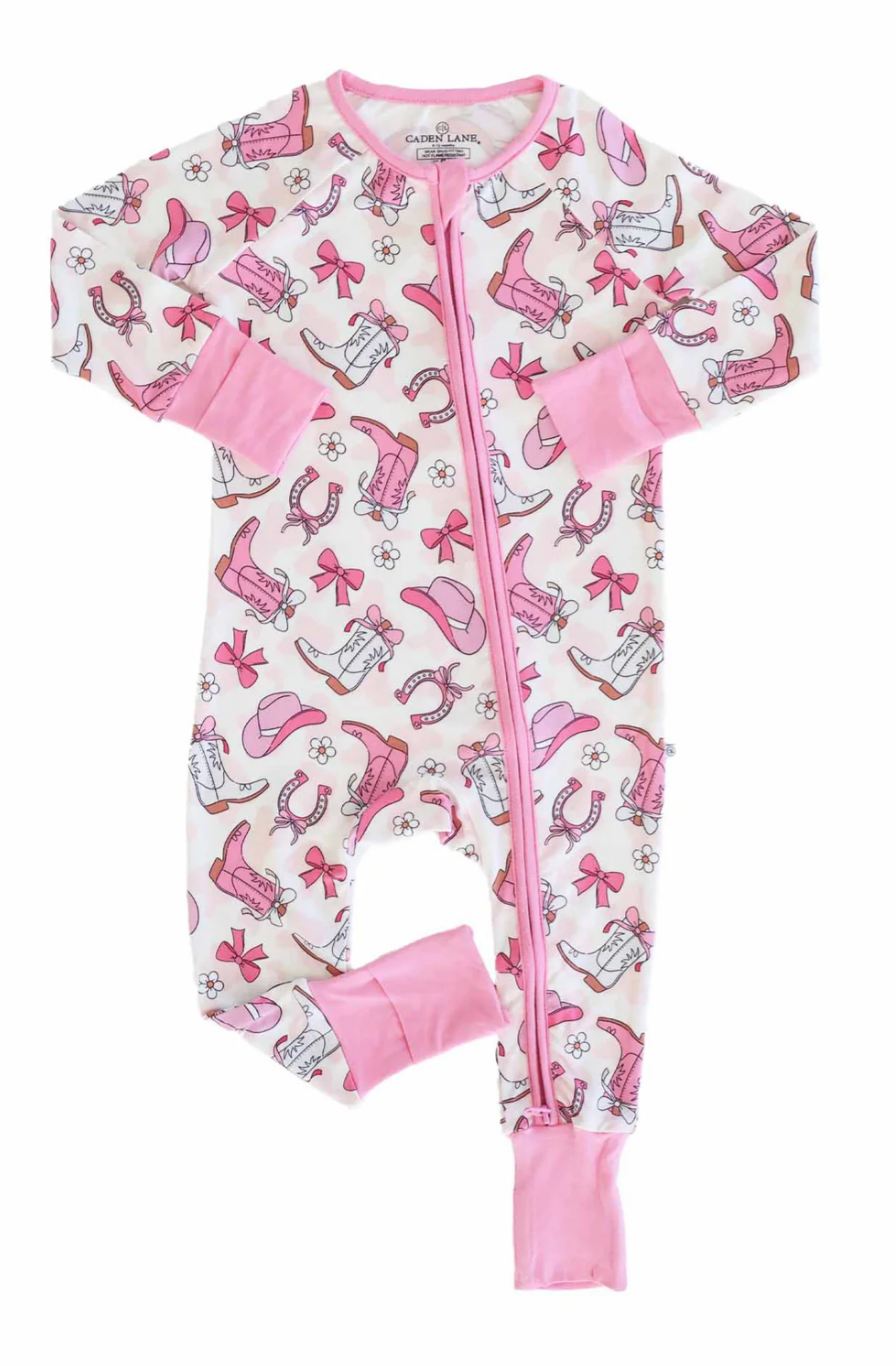 Discover the Rodeo Dreams Convertible Zip Romper | Pink by Caden Lane—a soft bamboo viscose romper featuring a pink zipper, cuffs, and Western-themed prints in pink and brown on white.