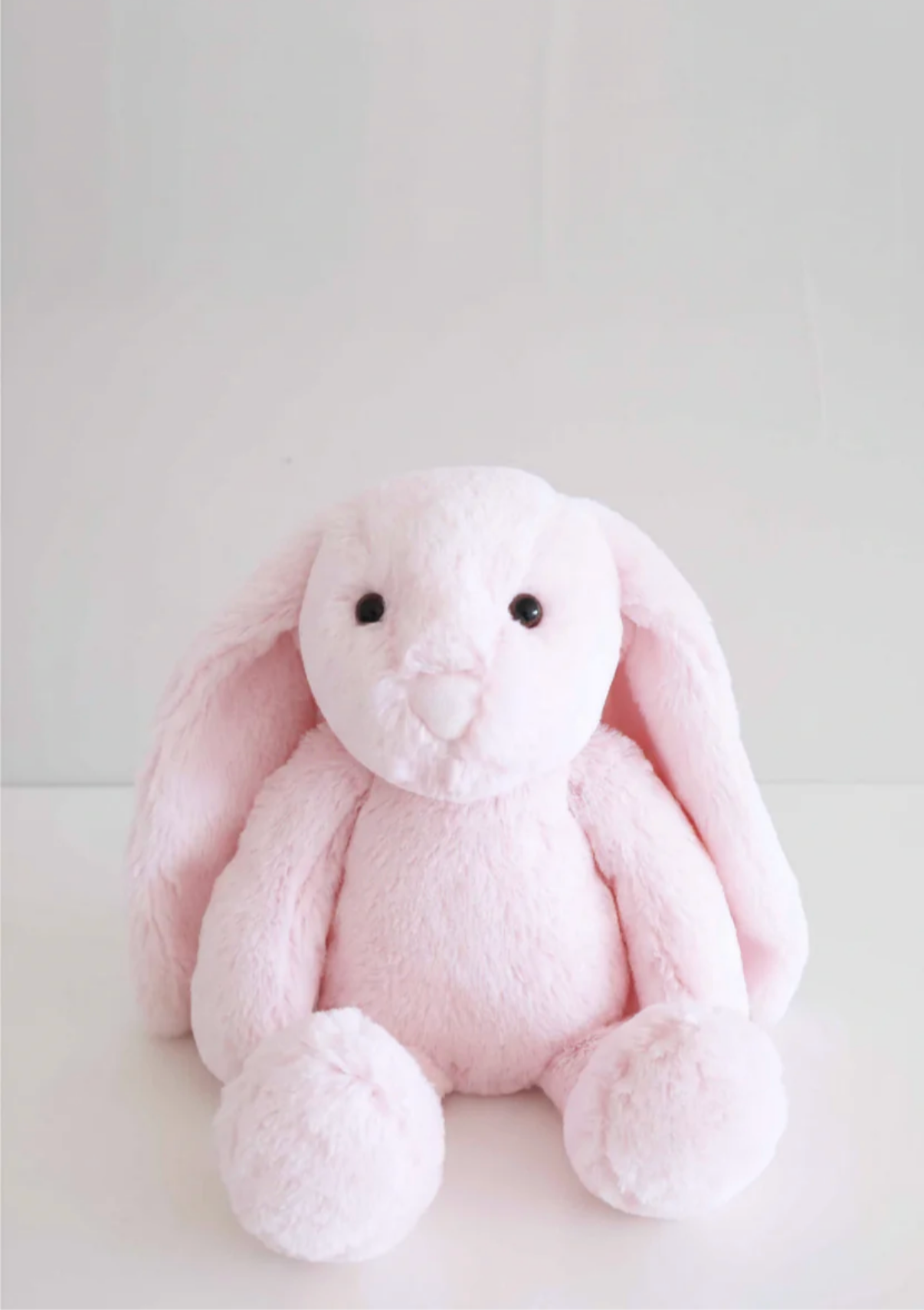 The Caden Lane Large Cuddle Plush Friends | Honey Bunny is a soft, light pink bunny with long floppy ears and black button eyes—an adorable, machine washable plush that's the perfect gift for newborns.