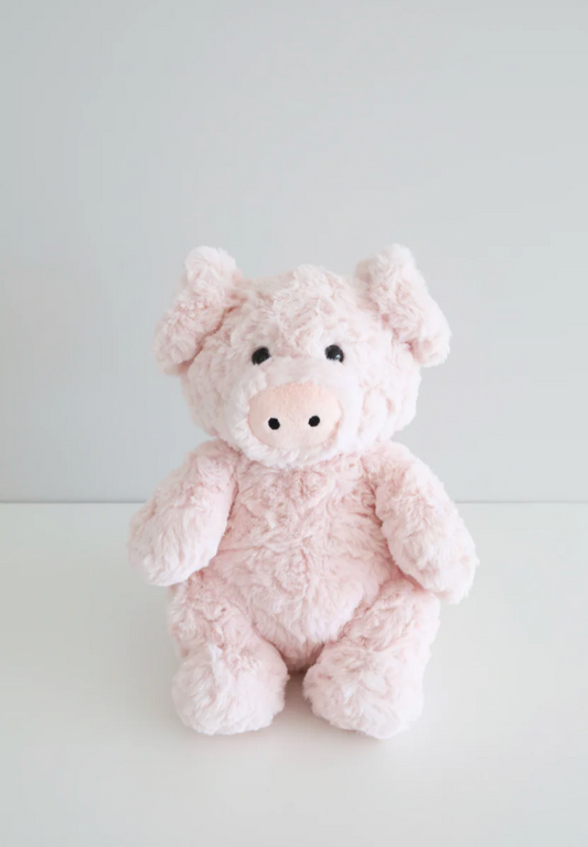 The Caden Lane Large Cuddle Plush Friends | Piper Pig is a soft, light pink plush toy with black eyes and a round snout, sitting upright on a white surface against a plain light gray background.