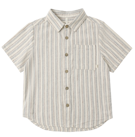 The Rylee & Cru Nautical Stripe Collared Shirt is a short-sleeve, button-up top with a front pocket, featuring vertical marine blue and beige stripes on a crisp white background.