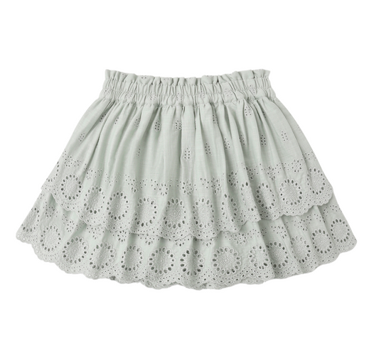 The Rose Seafoam Mini Skirt by Rylee & Cru features a light gray, tiered silhouette with an elastic waistband and circular eyelet embroidery on each ruffled layer—ideal as a breezy beach cover-up.