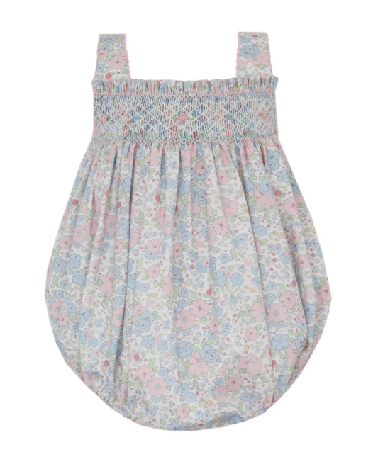 The Petie Bebe Caroline Pink and Blue Liberty Floral Strap Sunbubble is a sleeveless romper with adjustable straps, smocked chest, and pastel blue, pink, and green floral print on white.
