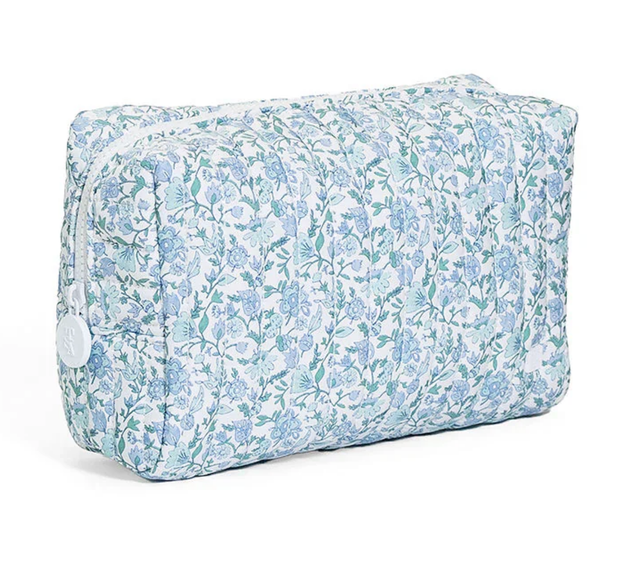 The TRVL QUILTED EVERYDAY BAG by TRVL is a rectangular, machine-washable pouch with a white zipper and a blue and green floral print on a white background.