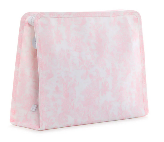 A soft, triangular foam wedge pillow in pale pink and white pattern stands upright with rounded edges—perfect to pair with the TRVL Large Roadie Bag by TRVL for added comfort and organization on your travels.