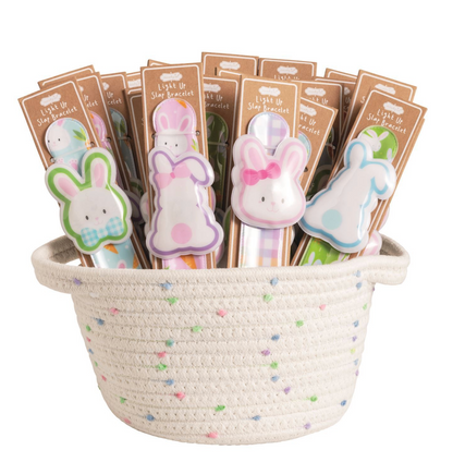The Mud Pie Easter LED Slapbands by mudpie are bunny-shaped, light-up bracelets in assorted colors—great as kids' party favors. Presented in a white woven basket with pastel accents.