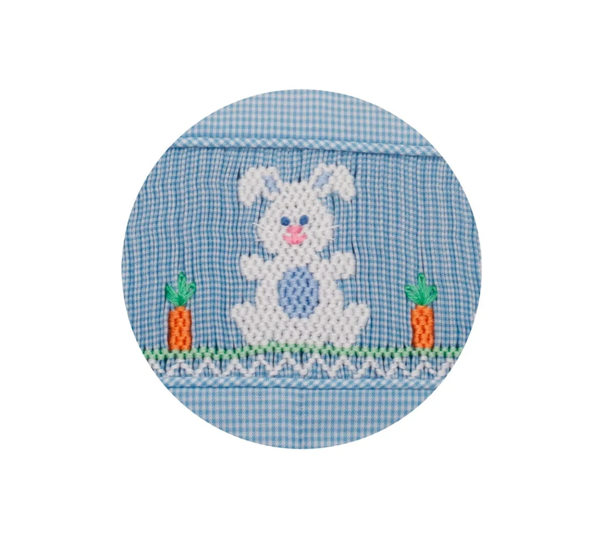 The Petie Bebe Bunnies Jon Jon features a white embroidered bunny with a pink nose between two orange carrots on light blue microcheck fabric, accented by green grass and a stitched decorative border.