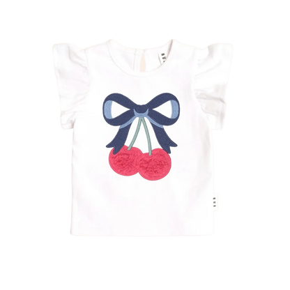 White t-shirt with a blue bow and red cherries design on a light pink background