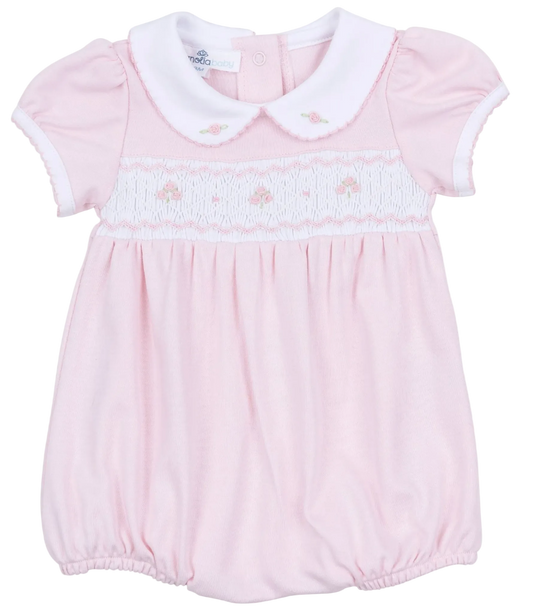 Pink baby romper with white collar on a white background