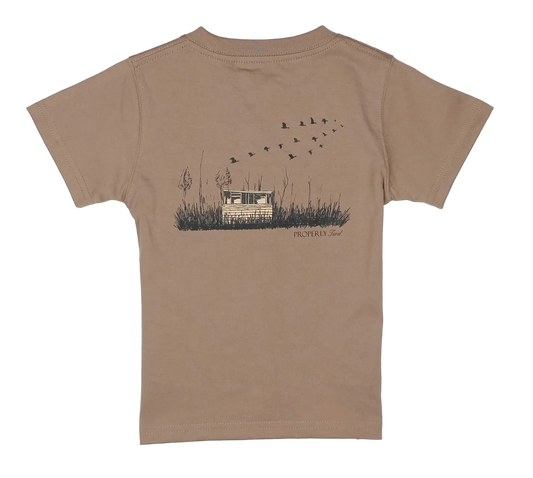 Brown t-shirt with a graphic of a duck blind and mallard ducks on the back, on a white background