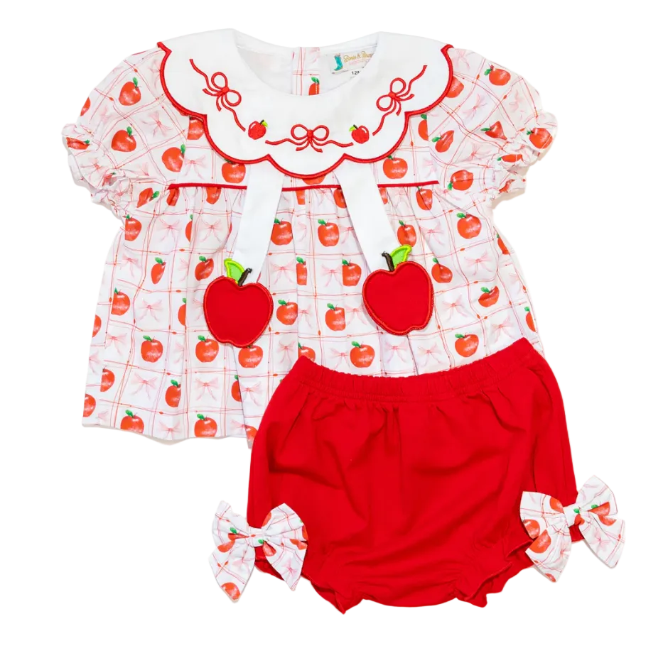 Baby outfit with apple pattern top and red bloomers on a white background