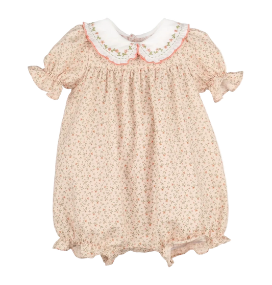 A baby girl's short-sleeve smocked dress in a light beige floral print, featuring a white Peter Pan collar with pink and green embroidered trim.