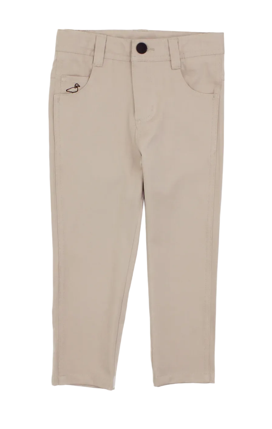 A pair of beige slim-fit pants for kids, featuring a button closure, belt loops, front pockets, and a small embroidered logo on the left pocket, shown against a plain white background.