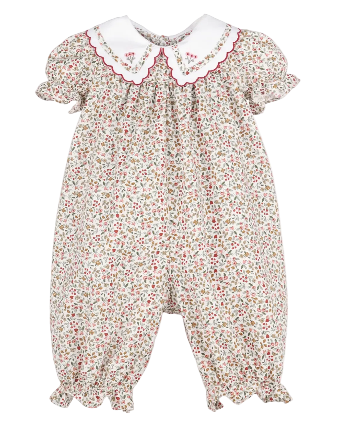 A baby romper with a dense red, green, and yellow floral print on a cream background, featuring a white Peter Pan collar with red embroidered details and scalloped edges.