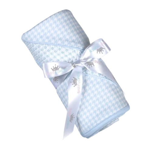 A light blue and white houndstooth patterned baby swaddle blanket wrapped in a white satin ribbon with a silver crown print and the brand name BABY CORNER.