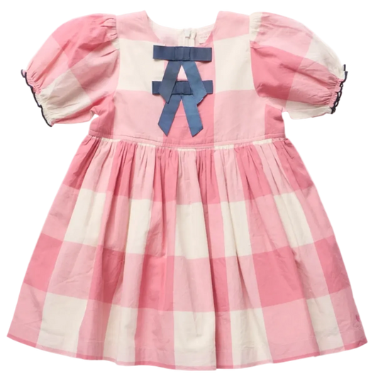 A pink and white gingham baby dress with puff sleeves, a gathered skirt, and a blue ribbon bow on the chest.