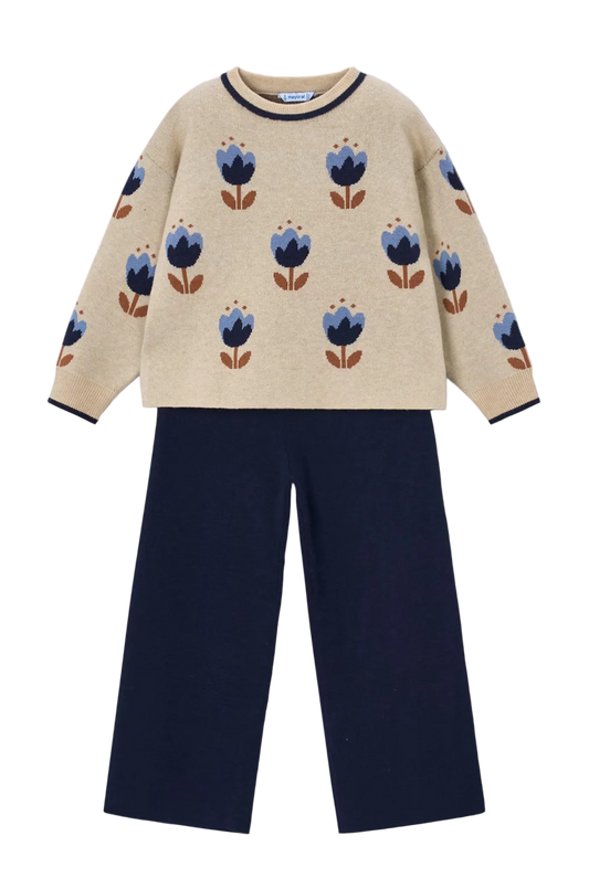 A children's knit two-piece set featuring a cream-colored long-sleeve top with a blue and brown floral pattern and navy trim, paired with navy wide-leg pants, shown flat on a light gray background.