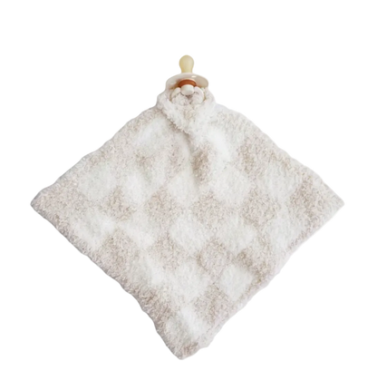 A soft, textured baby security blanket in a warm off-white or cream color, featuring a diamond pattern and a pacifier clip with a beige pacifier on a solid white background.