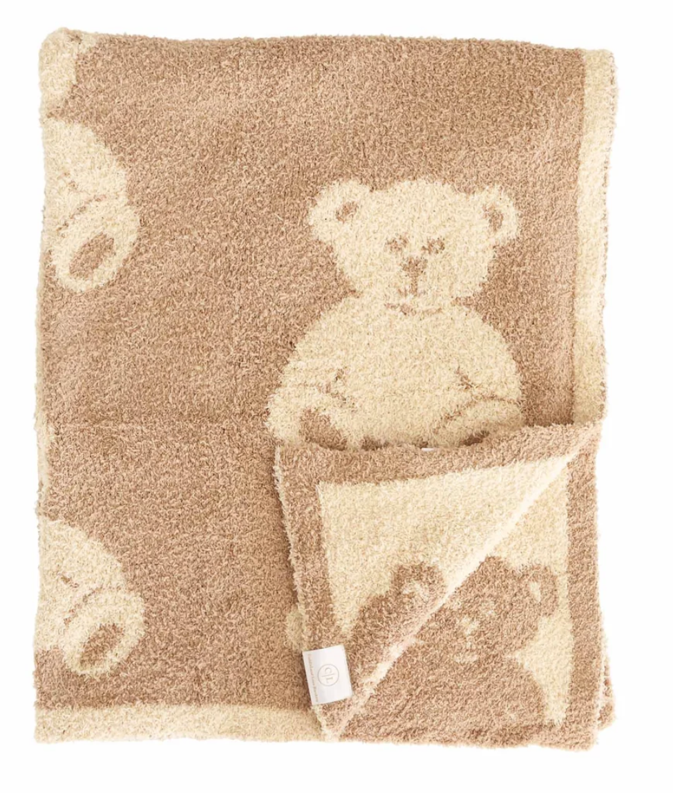 A plush teddy bear patterned baby blanket in shades of beige and cream, shown folded with its reverse side visible, on a plain white background.