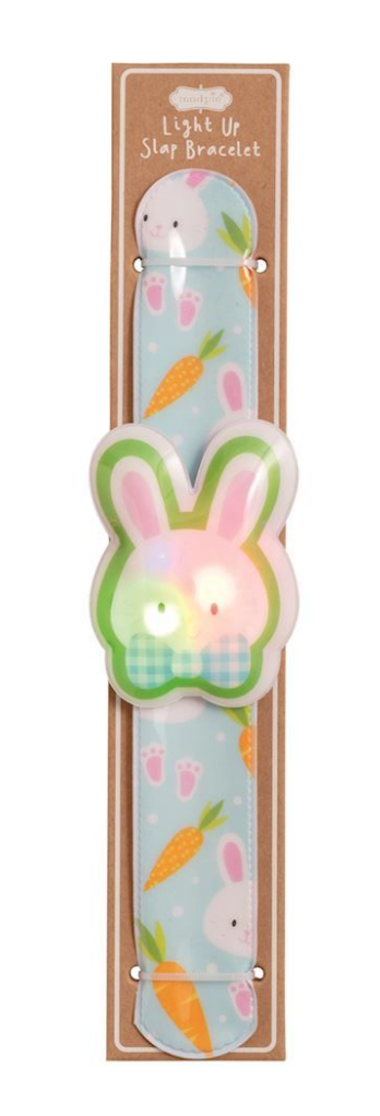 The mudpie Mud Pie Easter LED Slapbands feature a pastel blue band with white bunnies and orange carrots, topped with a glowing bunny face—perfect party favors for kids, displayed on brown cardboard backing.
