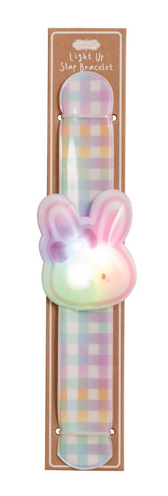 The Mud Pie Easter LED Slapband by mudpie features a pastel plaid design and a glowing bunny face in pink, purple, and green. Packaged on cardboard, it lights up white and green—ideal as a kids party favor or stylish light-up accessory.