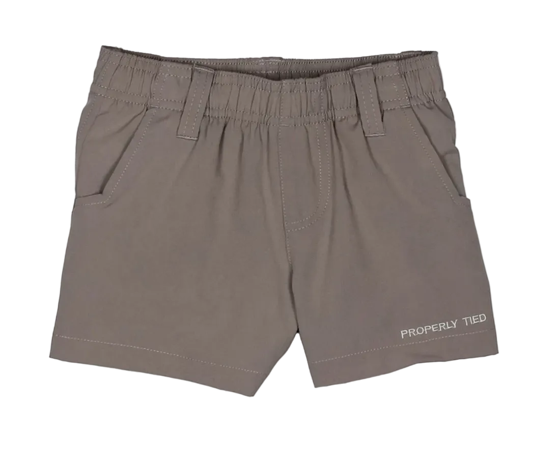 A pair of children's taupe-brown elastic waist shorts with side pockets and the brand name 'PROPERLY TIED' printed in white on the lower left leg, shown against a plain white background.