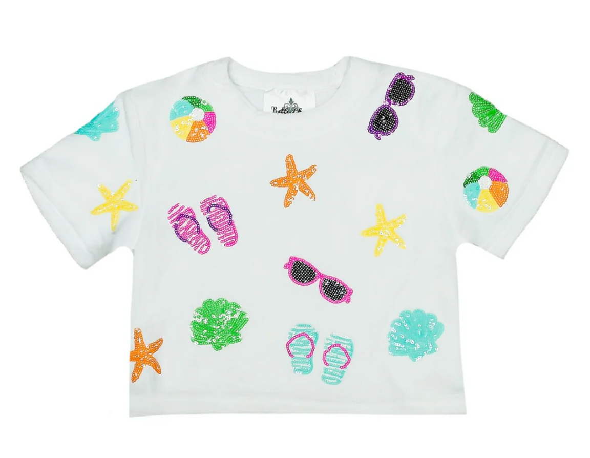 The Belle Cher Beach Terry Cloth Top features vibrant prints of sunglasses, starfish, beach balls, flip-flops, and seashells—perfect for spring break or pairing with your favorite beachwear for a fun summer look.