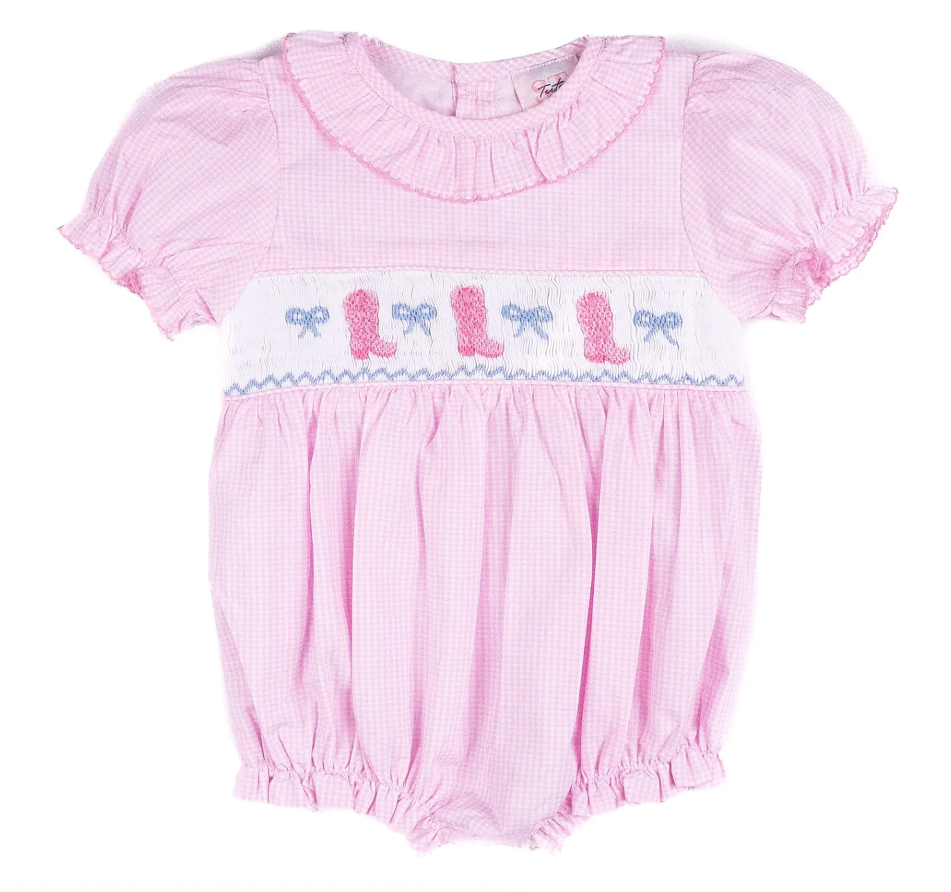 The Shop Teeta Cowgirl Bubble is a pink gingham romper with short puffed sleeves, ruffled collar, and smocked chest decorated with blue and pink embroidered bows and baby shoes. The fabric features a subtle checkered pattern.