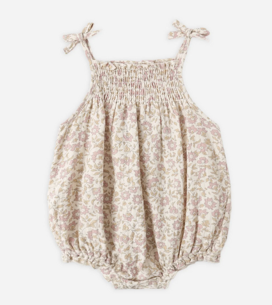 Floral-patterned baby romper with tie straps on a white background